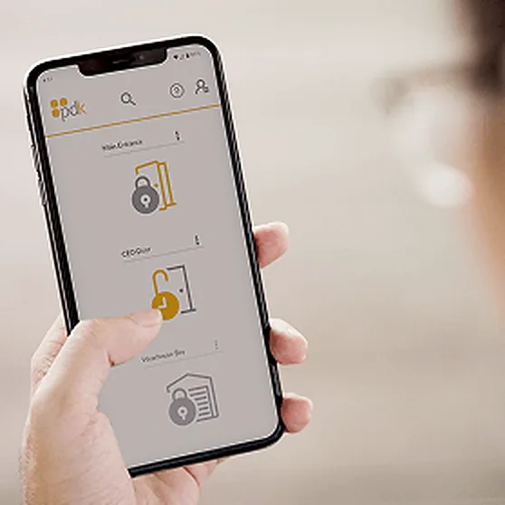 Hand holding a phone that shows an access-control app