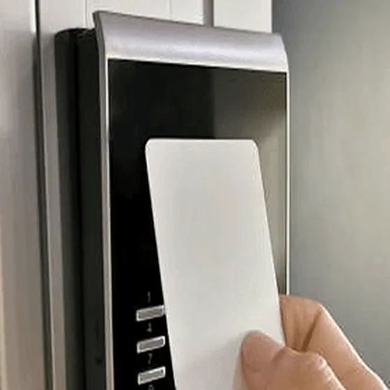 Access card held up to a wall-mounted card reader