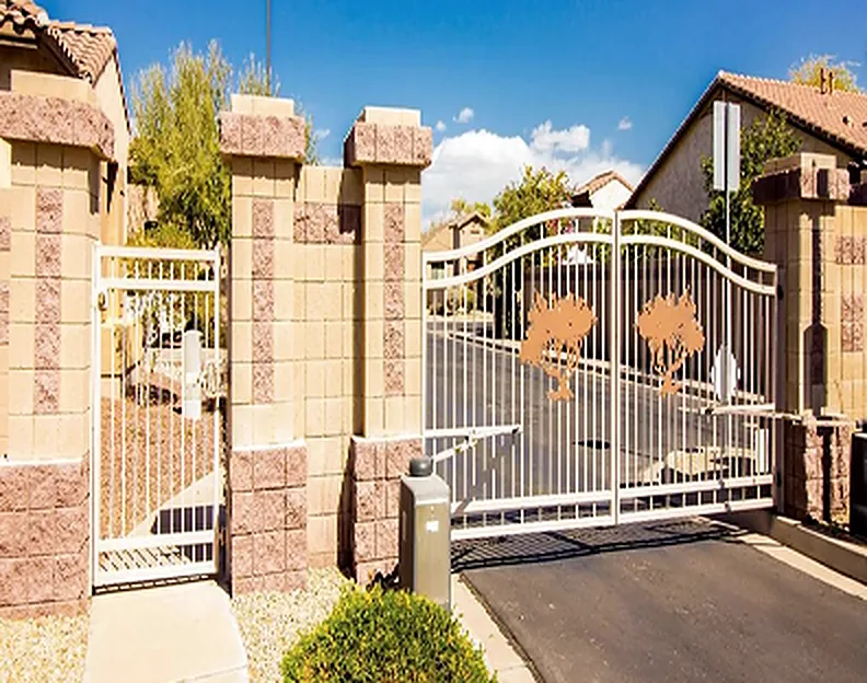 Community entry gate with tree-motif panels between block pillars