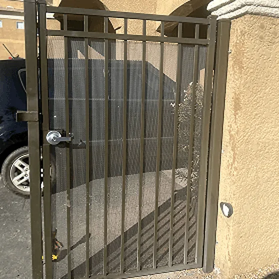 Pedestrian steel gate with a lever lock set between stucco walls