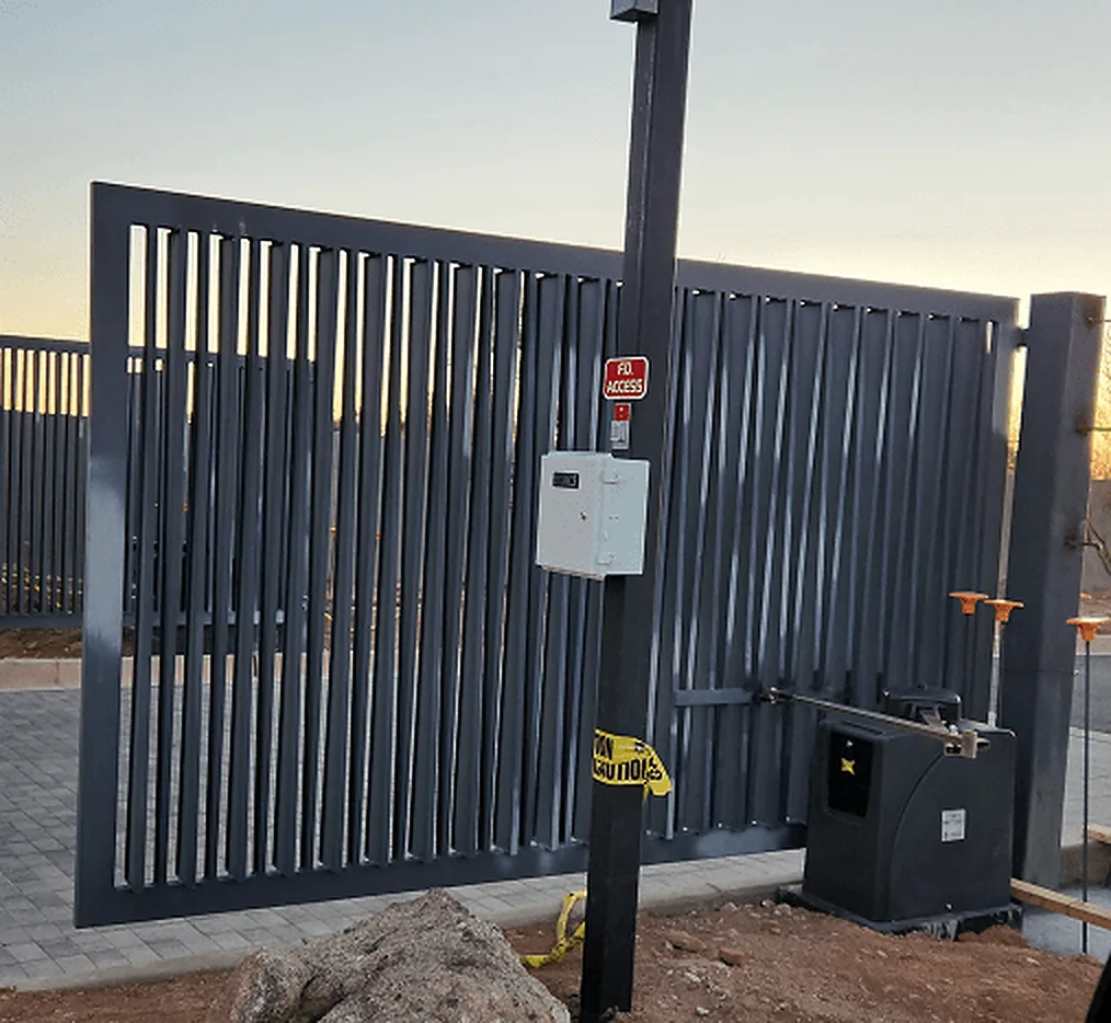 Slatted steel slide gate with its operator and a pole-mounted control box