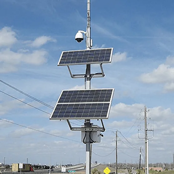 Solar surveillance pole with a dome camera beside a highway