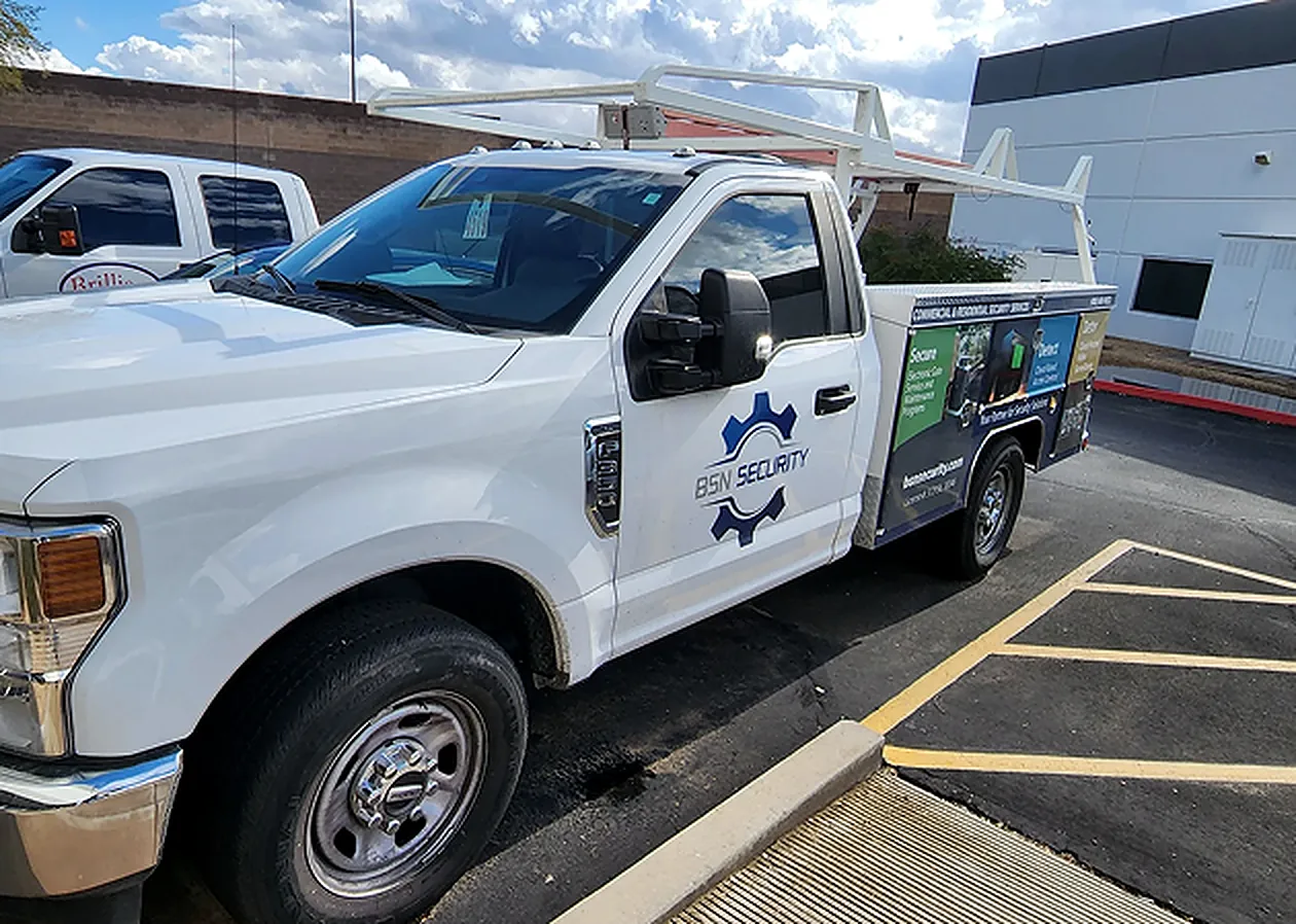 BSN Security service truck with the company logo on the door, parked at a commercial lot